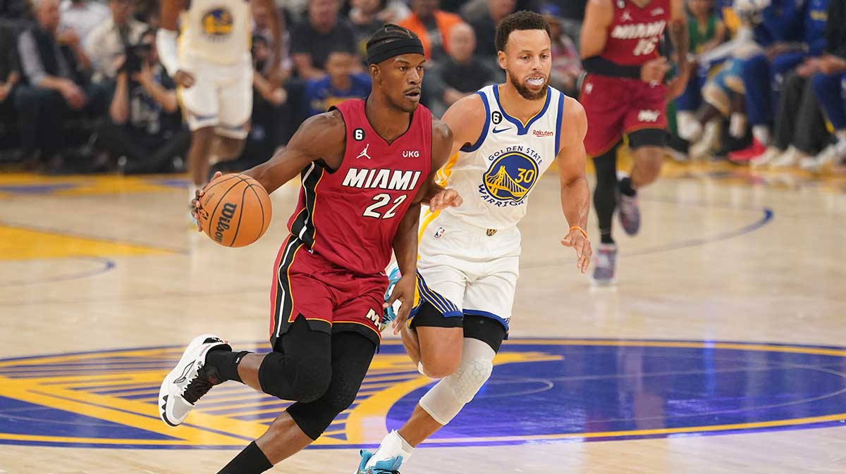 Miami Heat forward Jimmy Butler (22) dribbles past Golden State Warriors guard Stephen Curry (30) in the first quarter at the Chase Center.