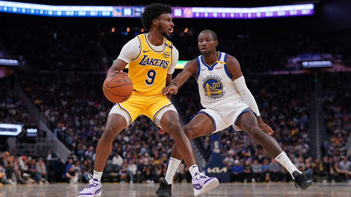 Los Angeles Lakers guard Bronny James (9) dribbles the ball next to Golden State Warriors forward Jonathan Kuminga (00) in the second quarter at the Chase Center.
