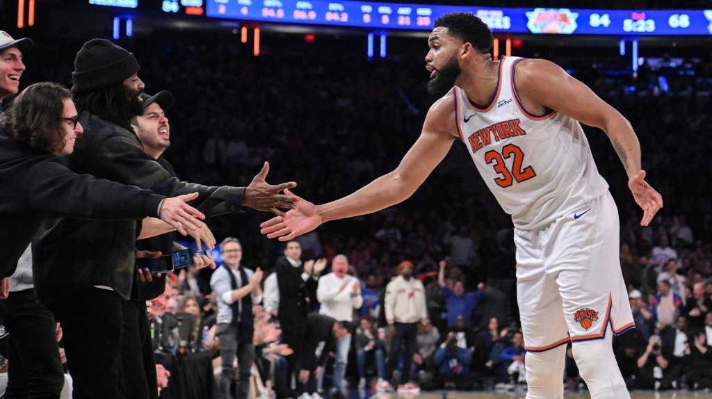 New York Knicks center Karl-Anthony Towns (32) slaps hands with fans during the second half against the Charlotte Hornets at Madison Square Garden.