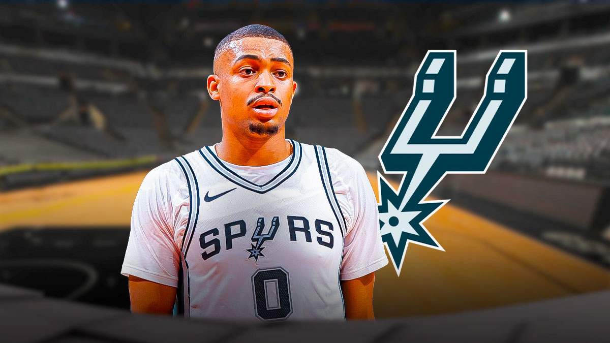 Keldon Johnson looking serious next to a Spurs logo