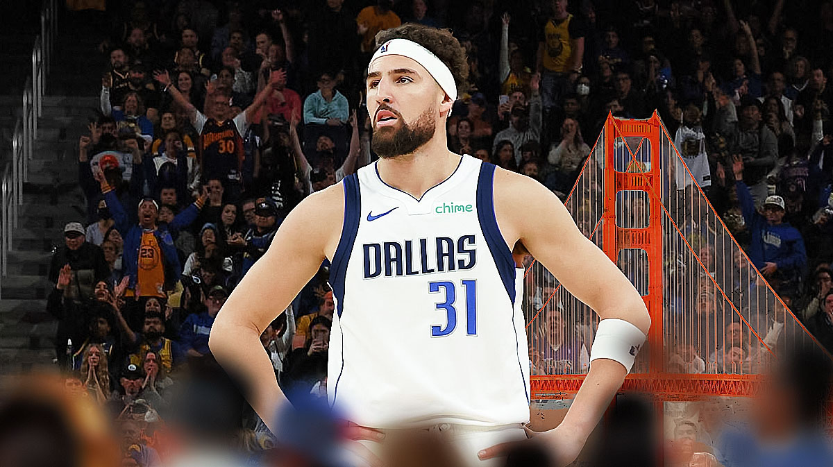 Mavericks' Klay Thompson walking on the court at Warriors' Chase Arena with the San Francisco skyline in the background