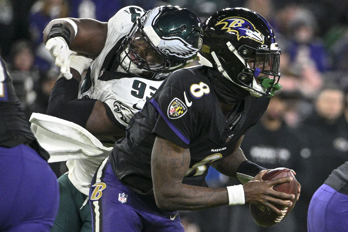 Baltimore Ravens quarterback Lamar Jackson (8) scrambles past Philadelphia Eagles defensive tackle Milton Williams (93) during the game at M&T Bank Stadium. 