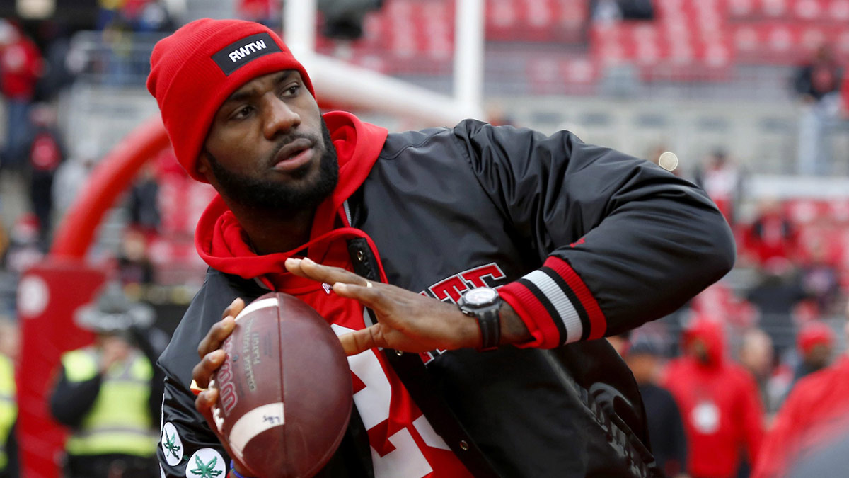 Cleveland Cavaliers player LeBron James plays catch with the Ohio State Buckeyes team before the game against the Michigan Wolverines at Ohio Stadium.