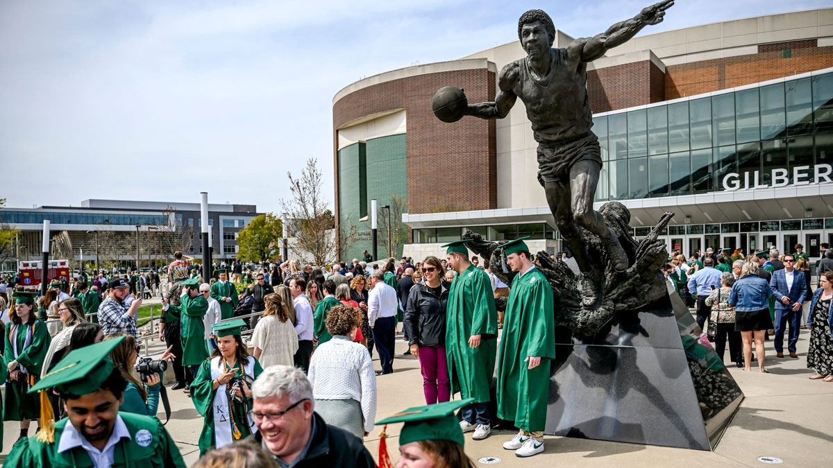 Graduated students of Michigan State Universities, family and friends hung out in front of Breslin Center and photograph the magical Johnson Statue after the MSU collection ceremony on Friday, 26. April 2024. Years in East Lansing.