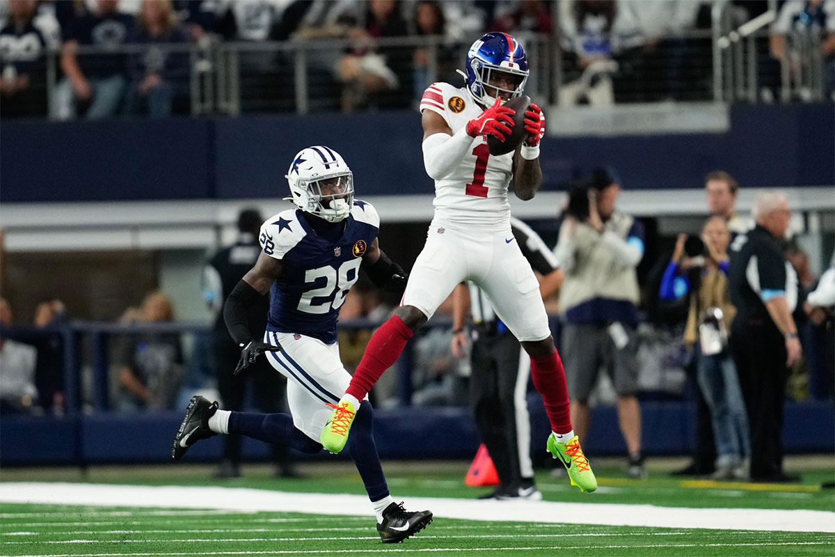 New York Giants wide receiver Malik Nabers (1) catches a pass as Dallas Cowboys safety Malik Hooker (28) gives chase during the first half at AT&T Stadium.