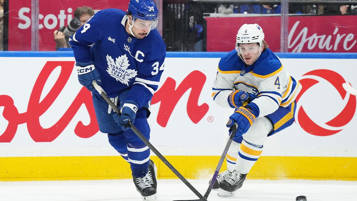 Toronto Maple Leafs center Auston Matthews (34) battles for the puck with Buffalo Sabres defenseman Bowen Byram (4) during the third period at Scotiabank Arena.