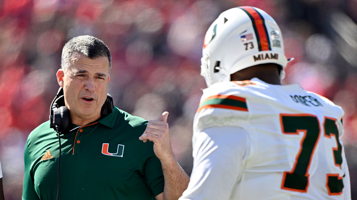 Miami Hurricanes head coach Mario Cristobal talks with offensive lineman Anez Cooper (73) during the first half against the Louisville Cardinals at L&N Federal Credit Union Stadium.