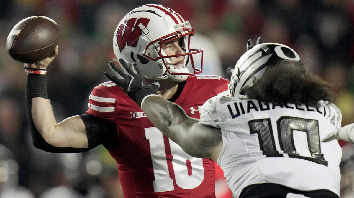 Wisconsin quarterback Braedyn Locke (18) is pressured by Oregon defensive end Matayo Uiagalelei (10) during the first quarter of their game Saturday, November 16, 2024 at Camp Randall Stadium in Madison, Wisconsin.