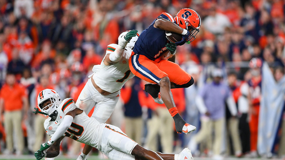 Syracuse Orange running back LeQuint Allen (1) leaps over Miami Hurricanes defensive back Zaquan Patterson (20) during the second half at the JMA Wireless Dome.