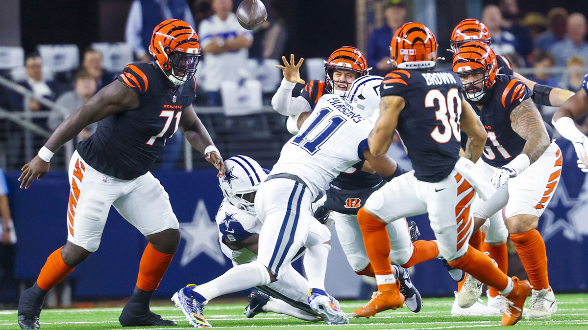 Dec 9, 2024; Arlington, Texas, USA; Cincinnati Bengals quarterback Joe Burrow (9) throws as Dallas Cowboys linebacker Micah Parsons (11) rushes during the first half at AT&T Stadium. 