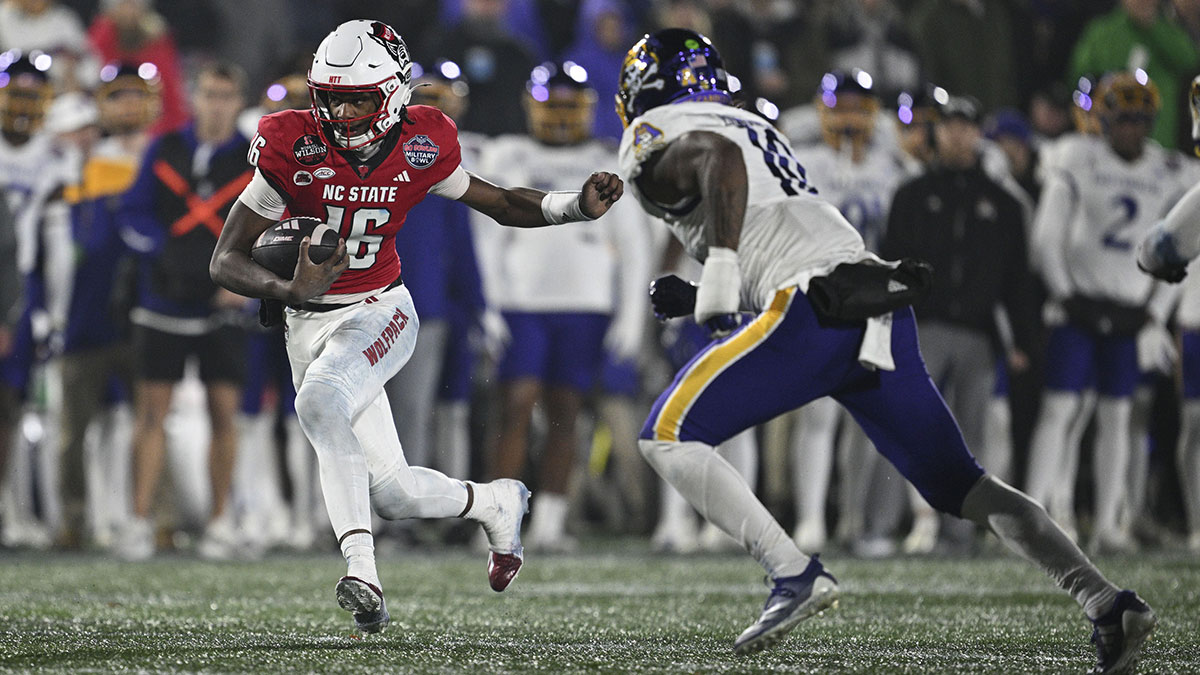North Carolina State Wolfpack quarterback CJ Bailey (16) scramble by East Carolina Pirates linebacker Mike Edwards III (10) during the second half of the Go Bowling Military Bowl at Navy-Marine Corps Memorial Stadium.
