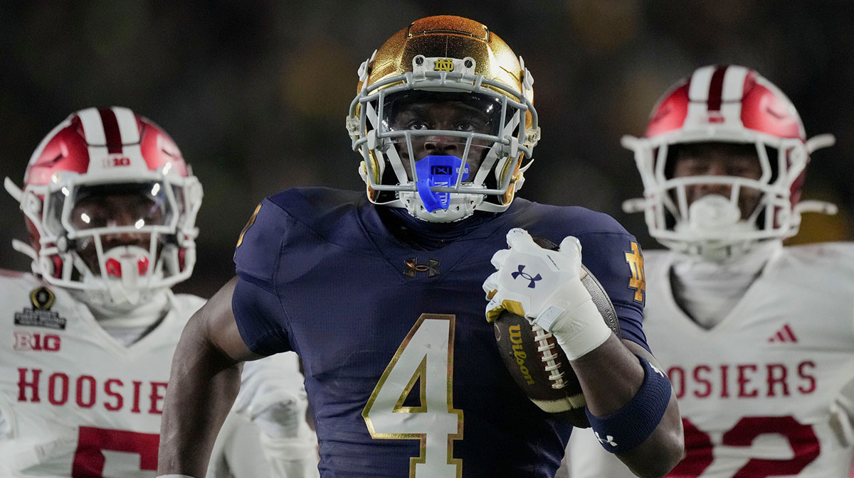 Notre Dame Fighting Irish running back Jeremiyah Love (4) scores a touchdown while being chased by Indiana Hoosiers defensive back D'Angelo Ponds (5) and Indiana Hoosiers defensive back Jamari Sharpe (22) during the first half of a game between the Indiana Hoosiers and the Notre Dame Fighting Irish in first round of the College Football Playoff on Friday, Dec. 20, 2024, in South Bend. 