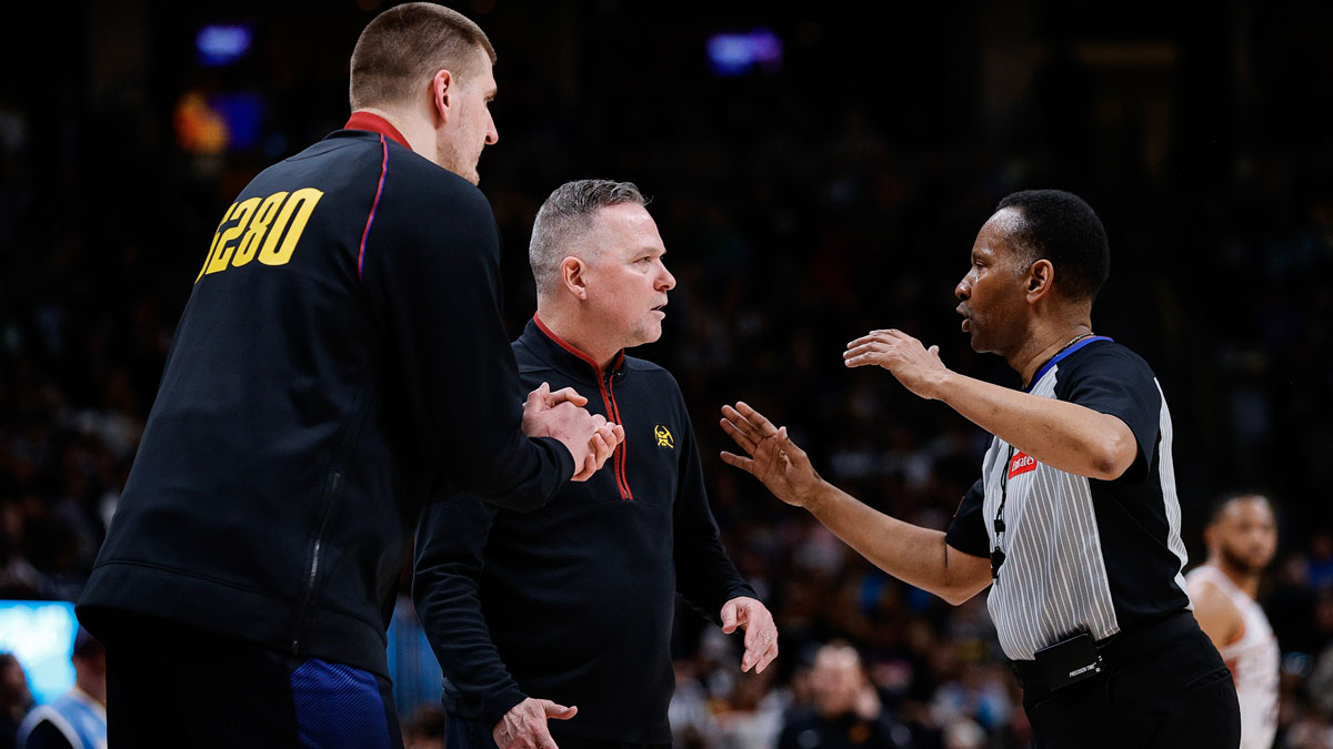 Denver Nuggets center Nikola Jokic (L) and head coach Michael Malone (C) argue a call with referee James Capers (R) in the second quarter against the Phoenix Suns at Ball Arena.