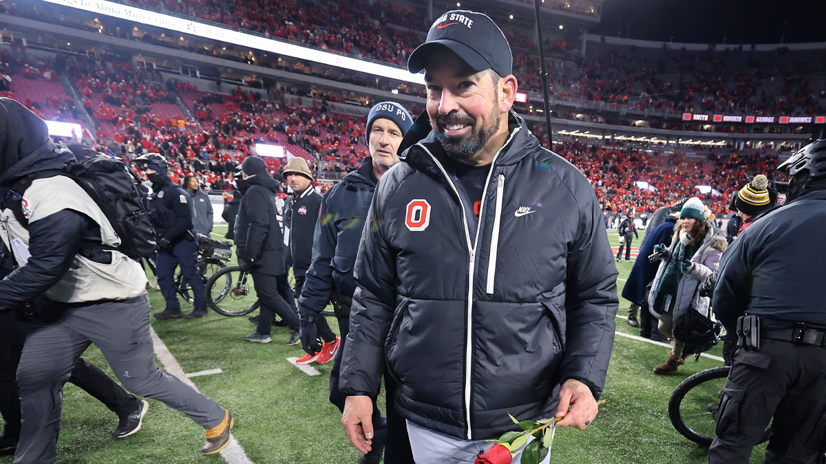 Ohio State Buckeyes head coach Ryan Day celebrates the win as he carries a rose after the game against the Tennessee Volunteers at Ohio Stadium.