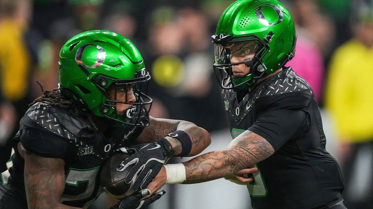 Oregon Ducks quarterback Dillon Gabriel (8) hands off the ball to Oregon Ducks running back Jordan James (20) on Saturday, Dec. 7, 2024, during the Big Ten Championship game at Lucas Oil Stadium in Indianapolis.