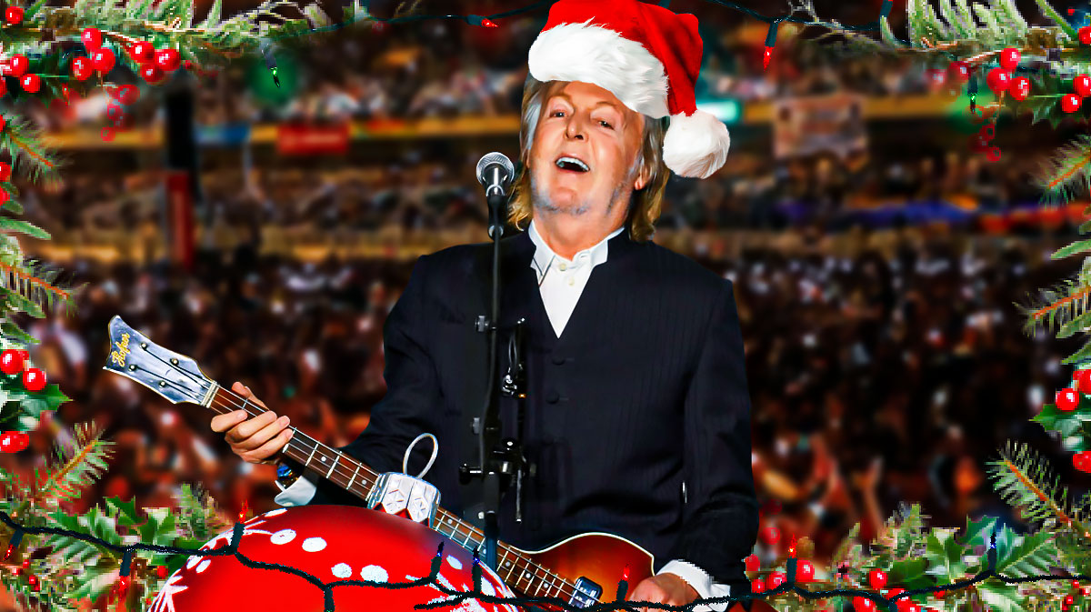 Wonderful Christmastime Christmas song singer Paul McCartney with Santa hat and concert crowd background.