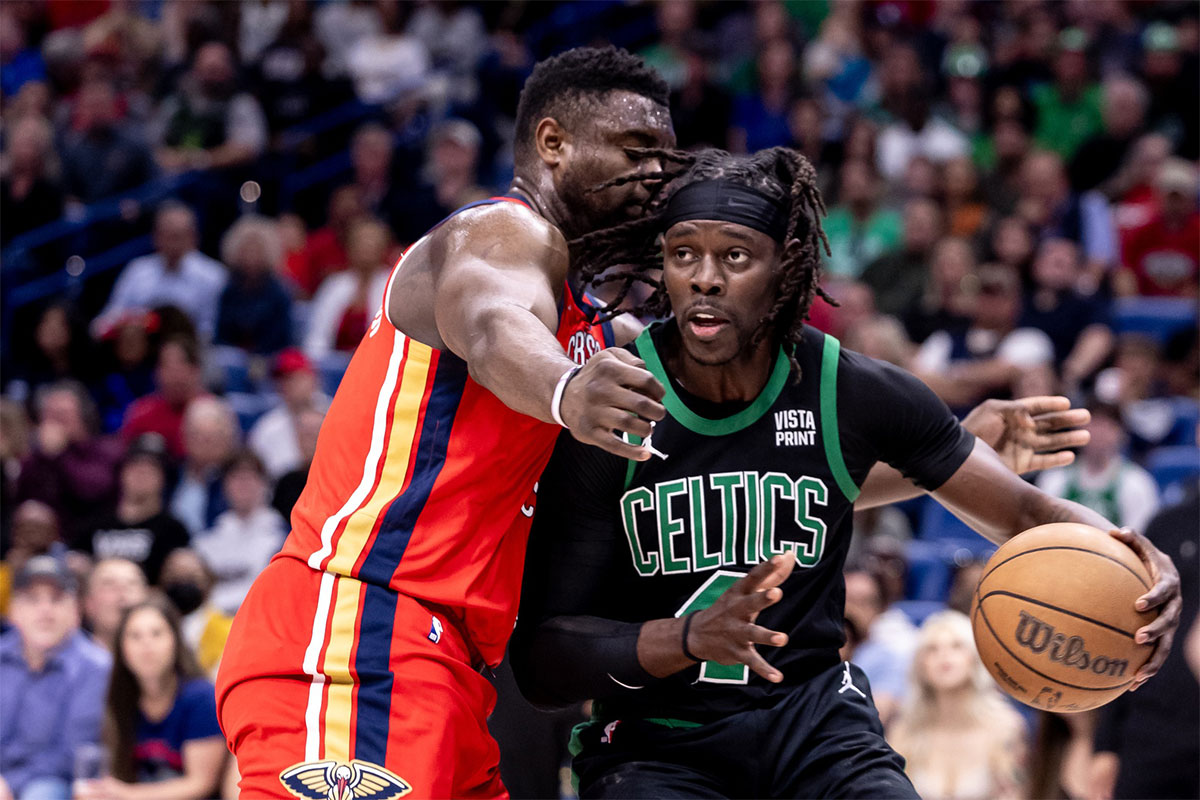 Boston Celtics guard Jrue Holiday (4) dribbles against New Orleans Pelicans forward Zion Williamson (1) during the first half at Smoothie King Center.