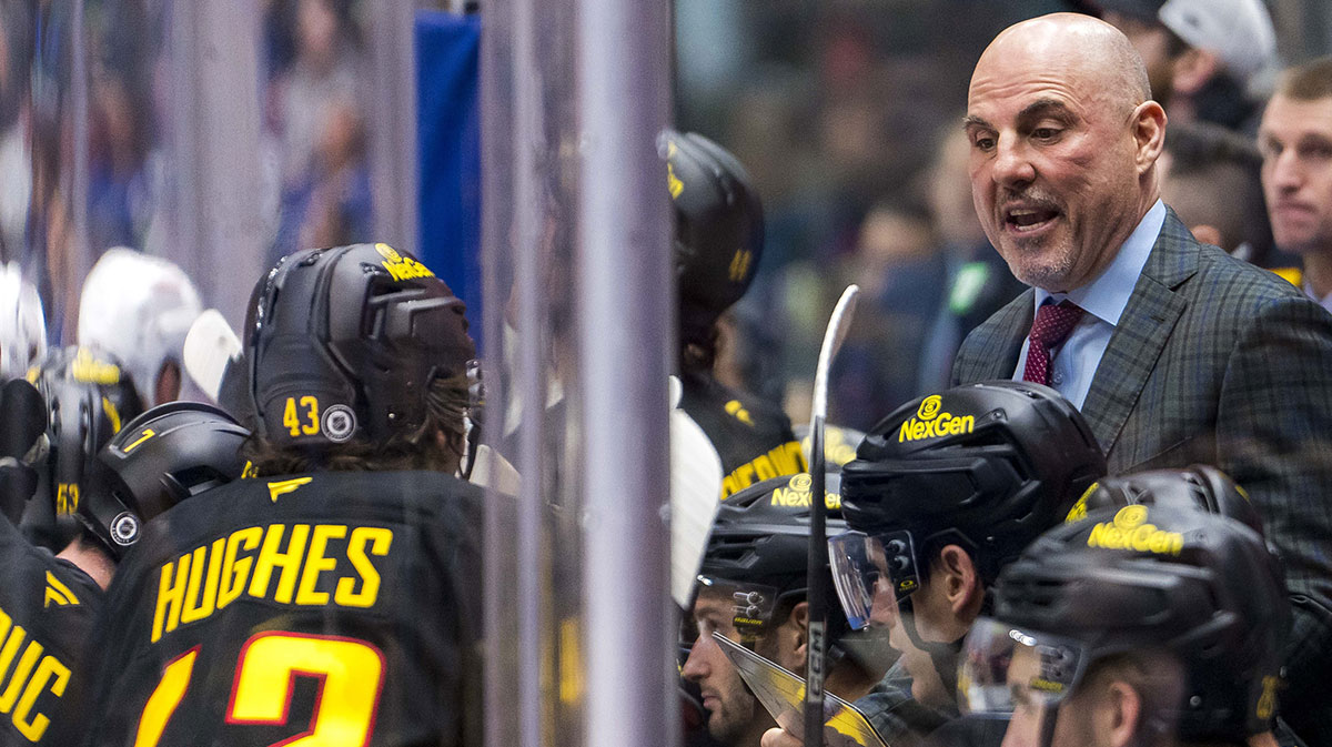Vancouver Canucks head coach Rick Tocchet talks with defenseman Quinn Hughes (43) on the bench against the Columbus Blue Jackets during the third period at Rogers Arena.