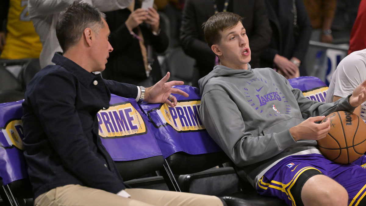 Los Angeles Lakers general manager Rob Pelinka, left, talks with guard Austin Reaves (15) prior to the game against the Orlando Magic at Crypto.com Arena.