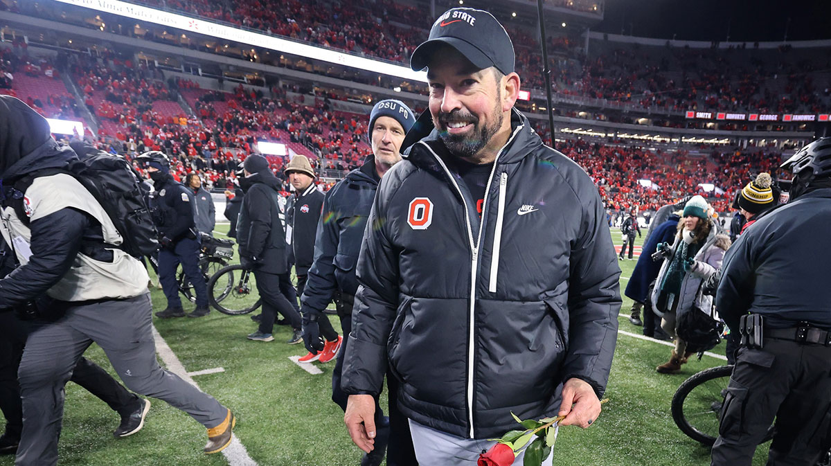 Ohio State Buckeyes head coach Ryan Day celebrates the win as he carries a rose after the game against the Tennessee Volunteers at Ohio Stadium.