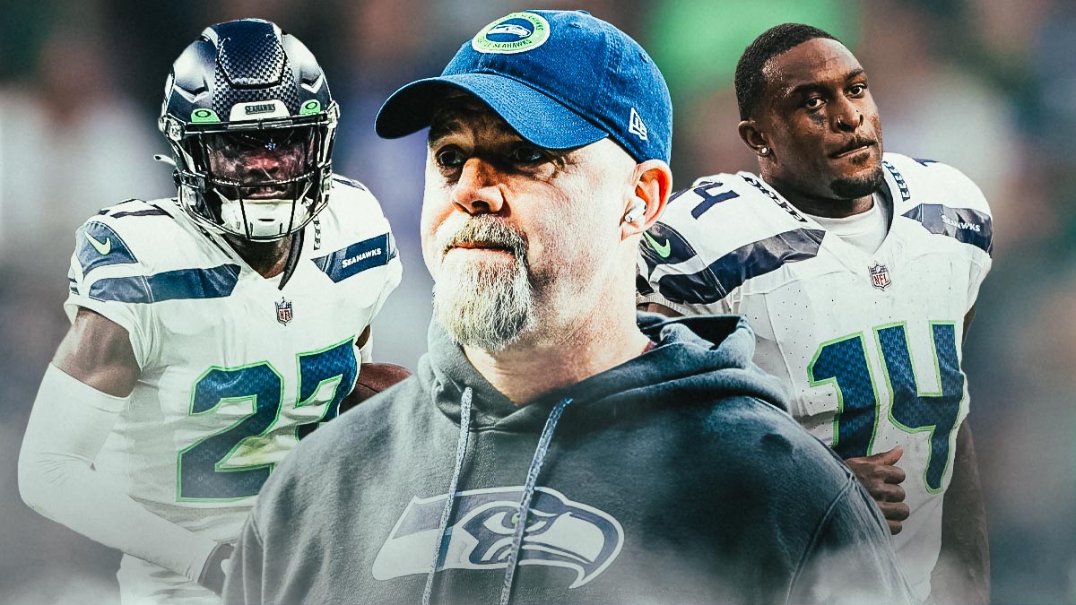 Coach Ryan Grubb in the middle, Tariq Woolen, DK Metcalf around him, Seattle Seahawks wallpaper in the background
