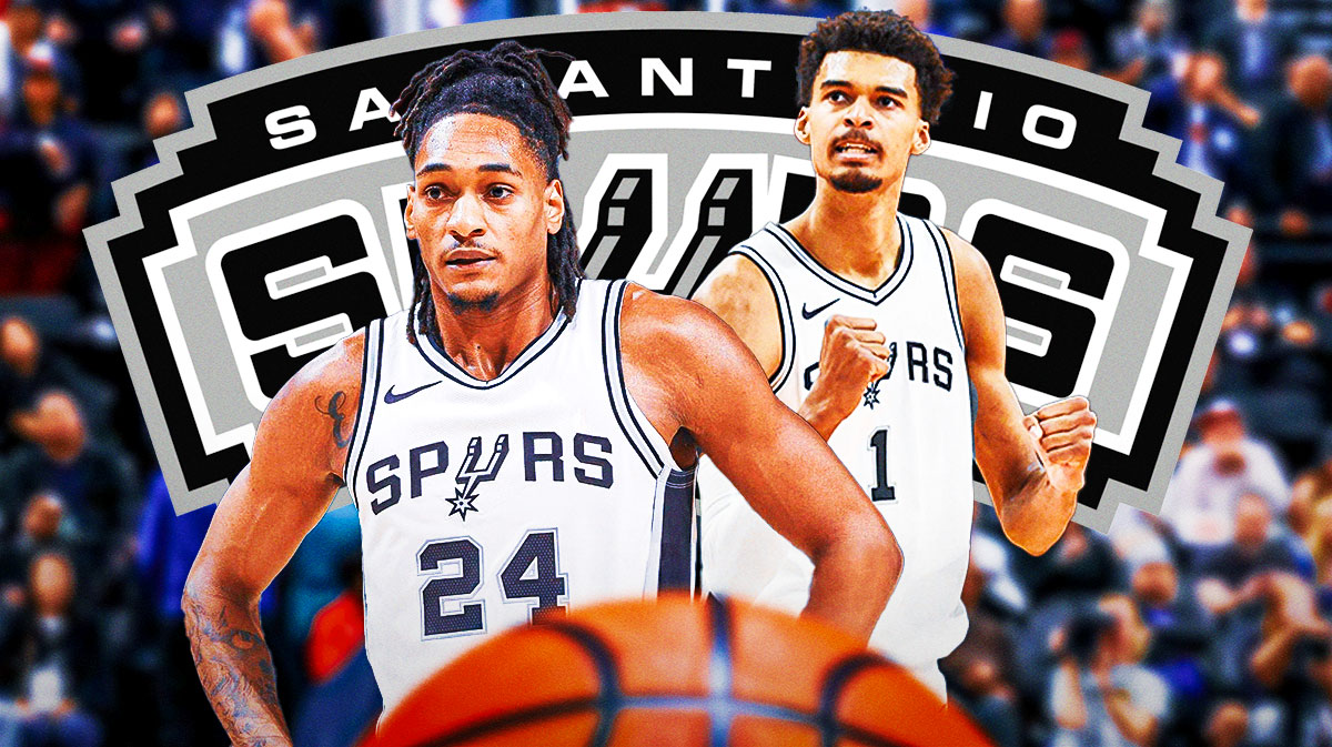 Devin Vassell and Victor Wembanyama looking fired up in front of a Spurs logo