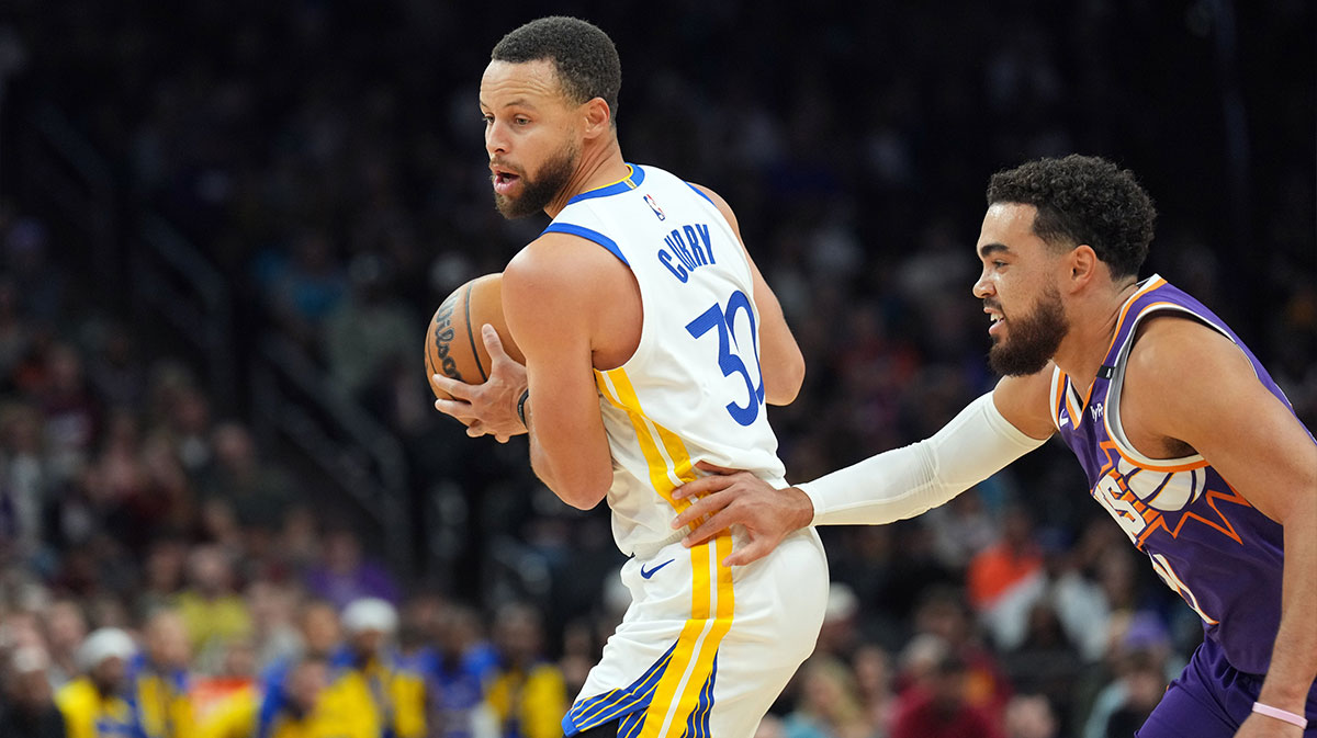 Golden State Warriors guard Stephen Curry (30) dribbles against Phoenix Suns guard Tyus Jones (21) during the first half at Footprint Center.