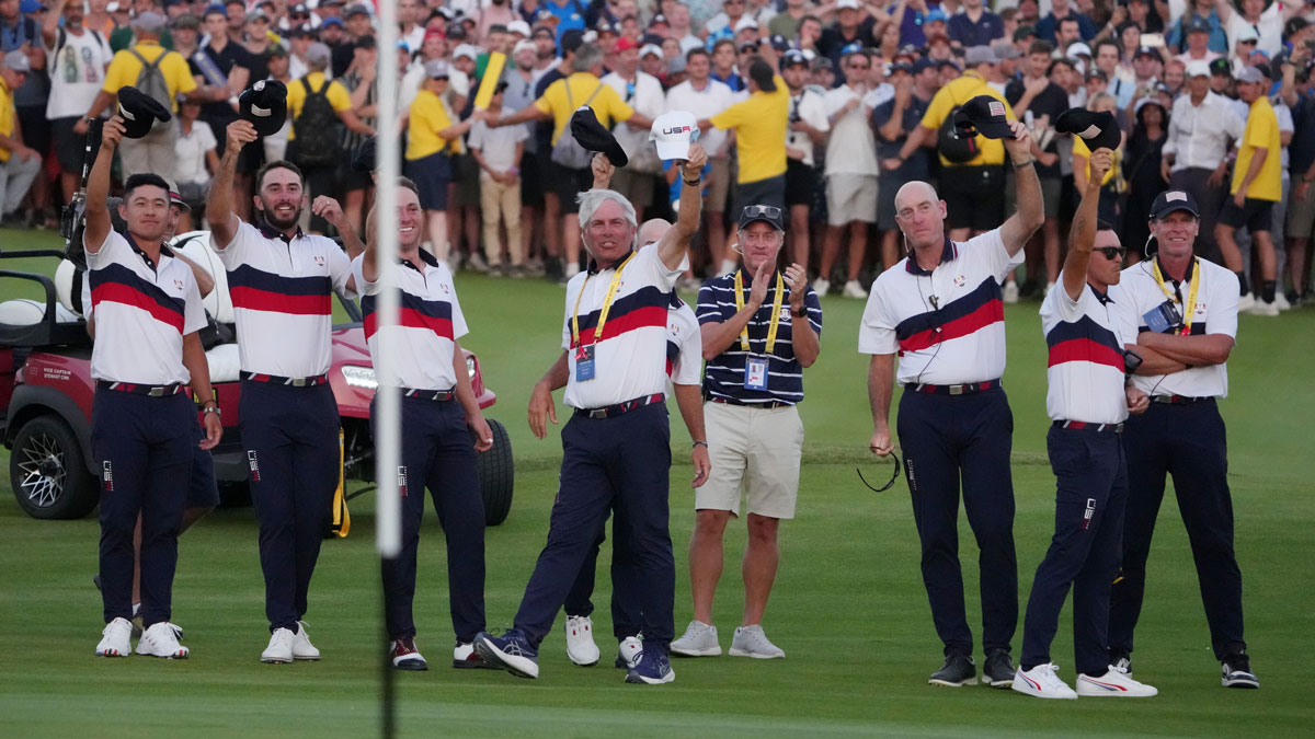 eam USA members hold up their hats after Team USA golfer Wyndham Clark putts on the 18th green during day two fourballs round for the 44th Ryder Cup golf competition at Marco Simone Golf and Country Club