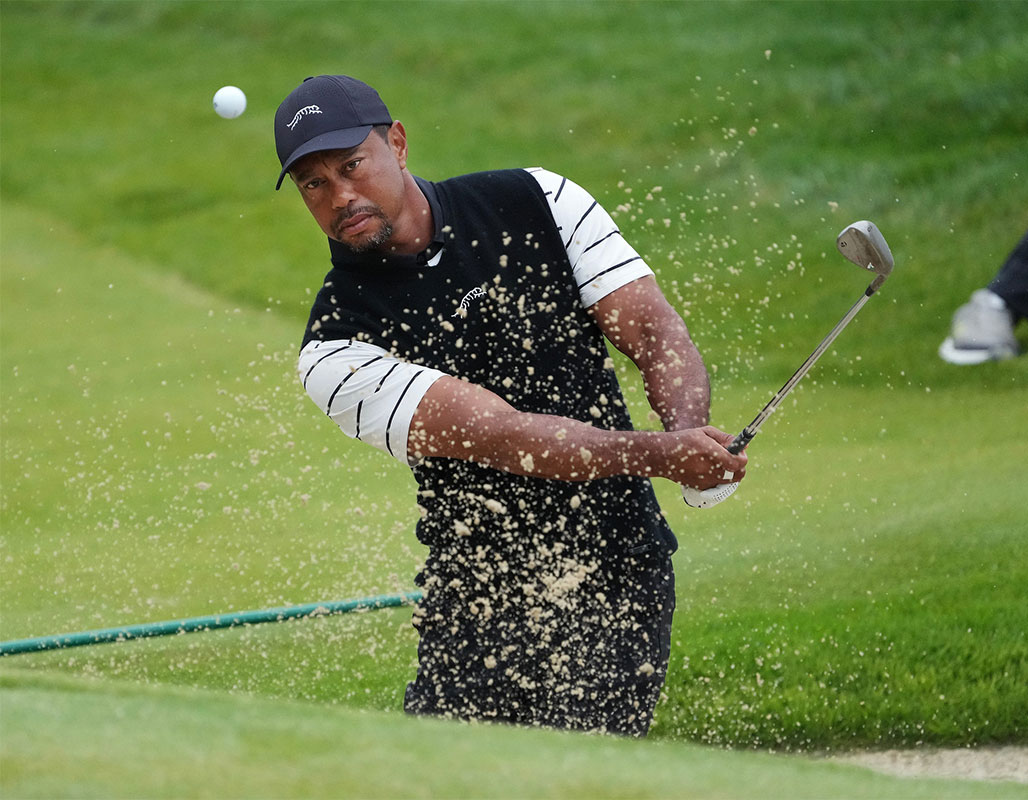Tiger Woods htis a bunker shot on the 3rd green during a practice round in the PGA Championship