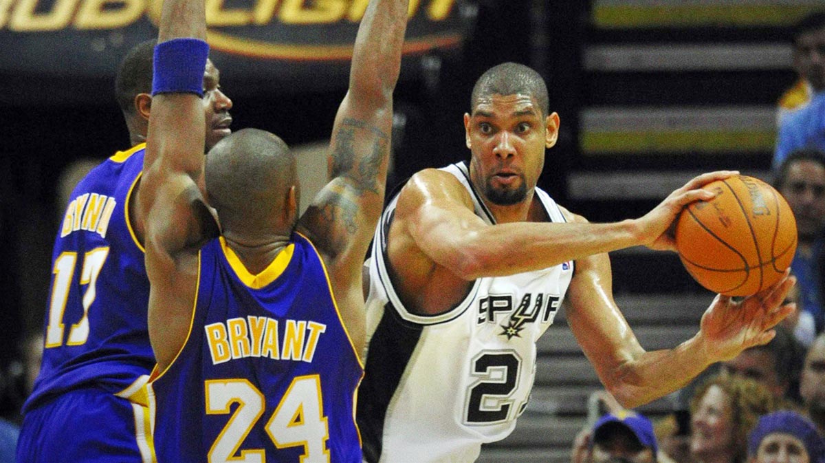 San Antonio Spurs forward Tim Duncan (right) passes around Los Angeles Lakers guard Kobe Bryant (24) and center Andrew Bynum (17) during the third quarter at the AT&T Center. San Antonio beat Los Angeles 105-85.