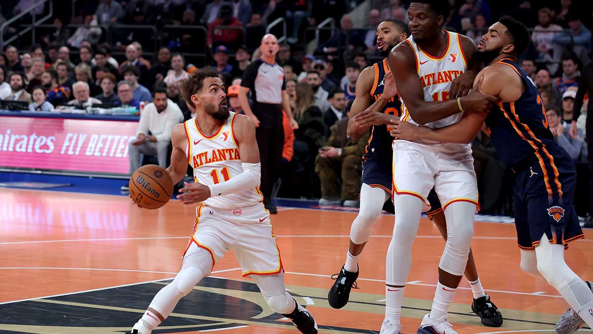 Atlanta Hawks guard Trae Young (11) drives to the basket against New York Knicks forward Mikal Bridges (25) and center Karl-Anthony Towns (32) during the first quarter at Madison Square Garden.