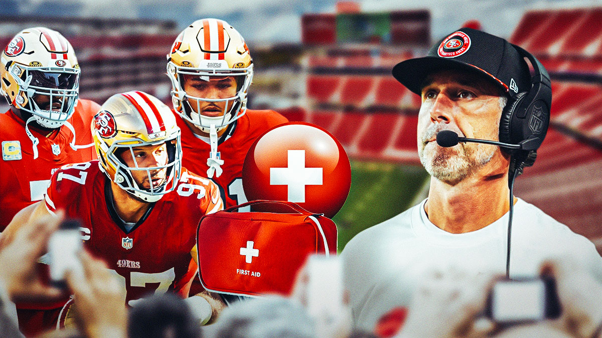 Trent Williams, Nick Bosa, and Isaac Guerendo with the injury cross and a med kit standing next to Kyle Shanahan