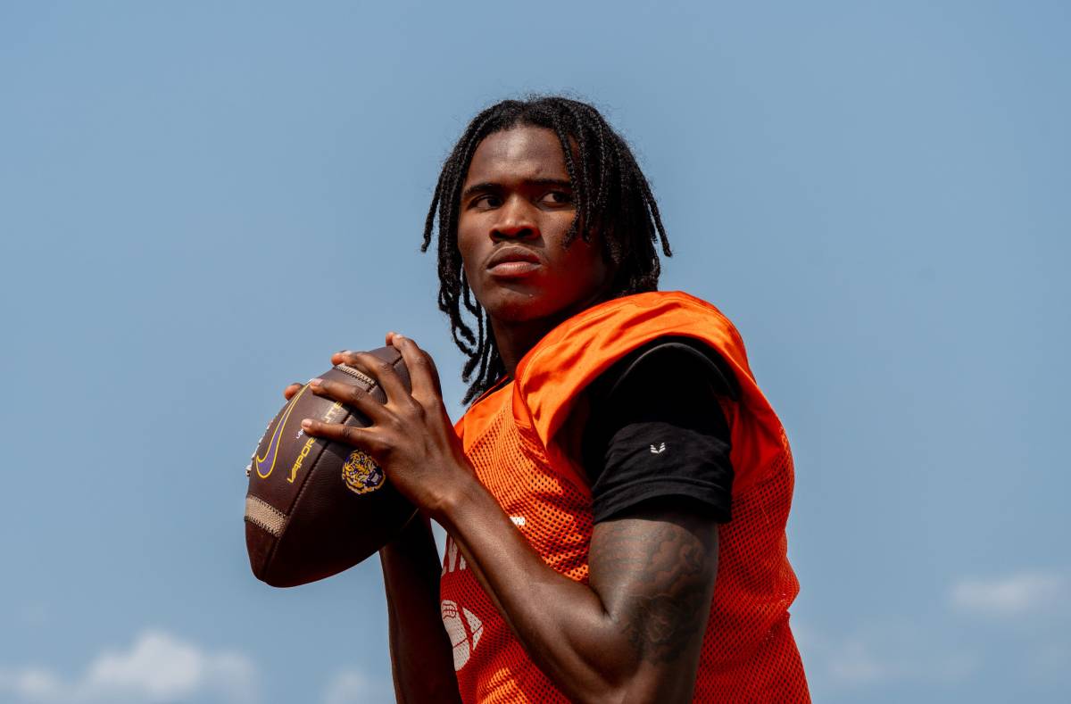 Quarterback Bryce Underwood prepares to throw a pass during a team practice at the Belleville High School football field