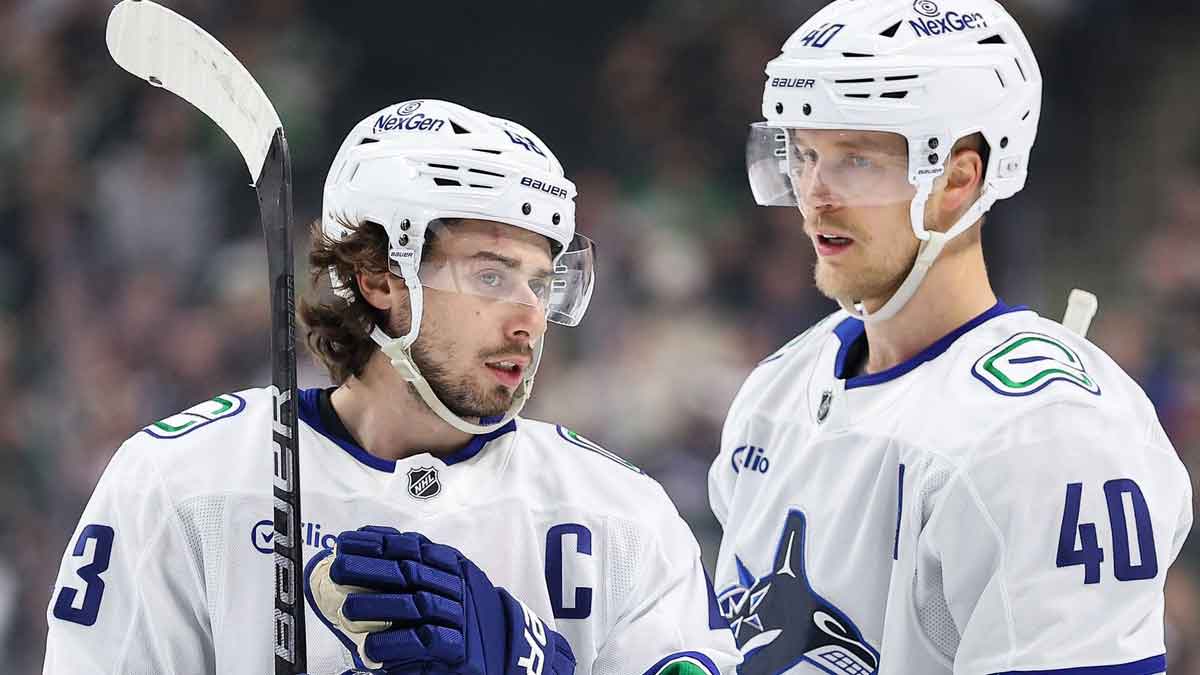 Vancouver Canucks defenseman Quinn Hughes (43) and center Elias Pettersson (40) talk before the game against the Minnesota Wild during the first period at the Xcel Energy Center.