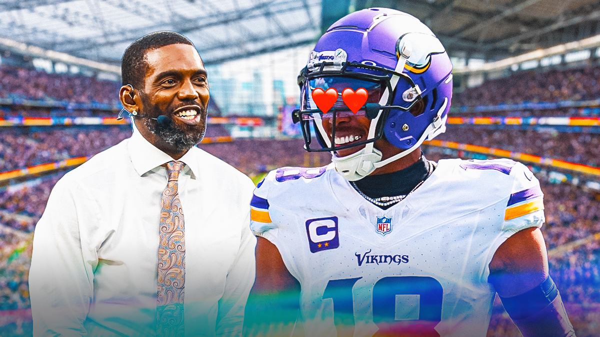 Vikings WR Justin Jefferson happy with heart eyes looking at current day Randy Moss. Background is US Bank Stadium.