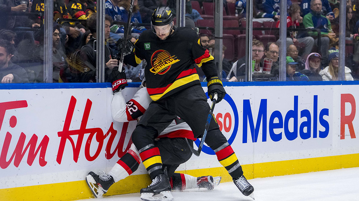 Vancouver Canucks defenseman Vincent Desharnais (73) checks Ottawa Senators forward Michael Amadio (22) during the third period at Rogers Arena.