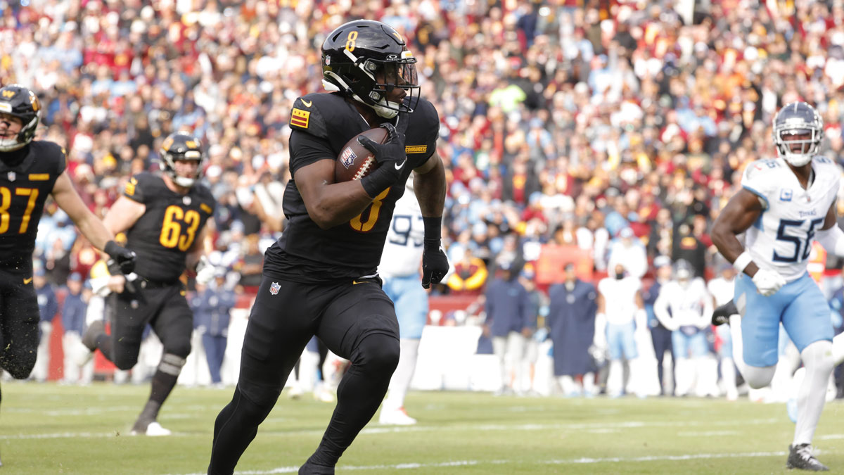 Washington Commanders running back Brian Robinson Jr. (8) carries the ball to score a touchdown against the Tennessee Titans during the first half at Northwest Stadium.