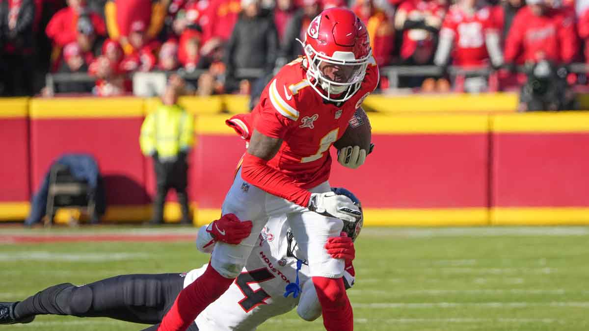 Kansas City Chiefs wide receiver Xavier Worthy (1) runs the ball as Houston Texans cornerback Kamari Lassiter (4) makes the tackle during the first half at GEHA Field at Arrowhead Stadium.