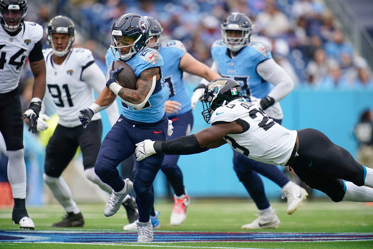 Tennessee Titans running back Tony Pollard (20) is stopped by Jacksonville Jaguars linebacker Foyesade Oluokun (23) during the first quarter at Nissan Stadium in Nashville, Tenn., Sunday, Dec. 8, 2024.