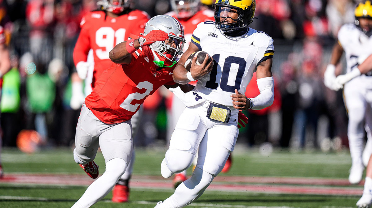 Michigan quarterback Alex Orji (10) runs against Ohio State safety Caleb Downs (2) during the first half at Ohio Stadium in Columbus, Ohio on Saturday, Nov. 30, 2024.