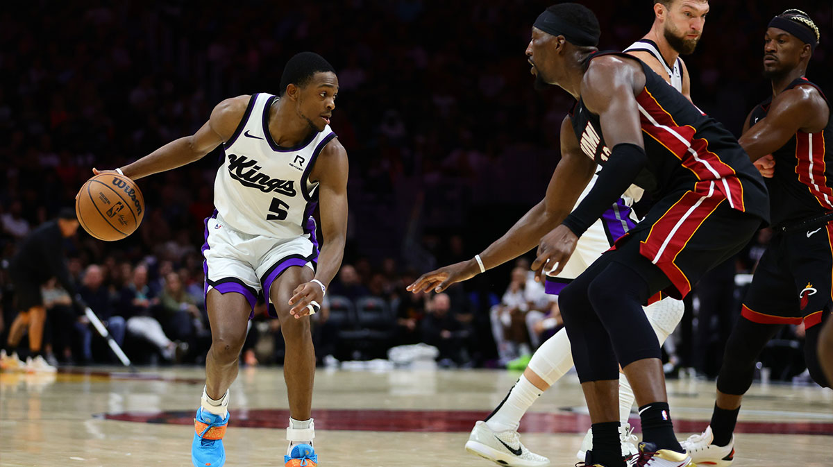 Sacramento Kings guard De'Aaron Fox (5) dribbles the basketball against Miami Heat center Bam Adebayo (13) during the third quarter at Kaseya Center.