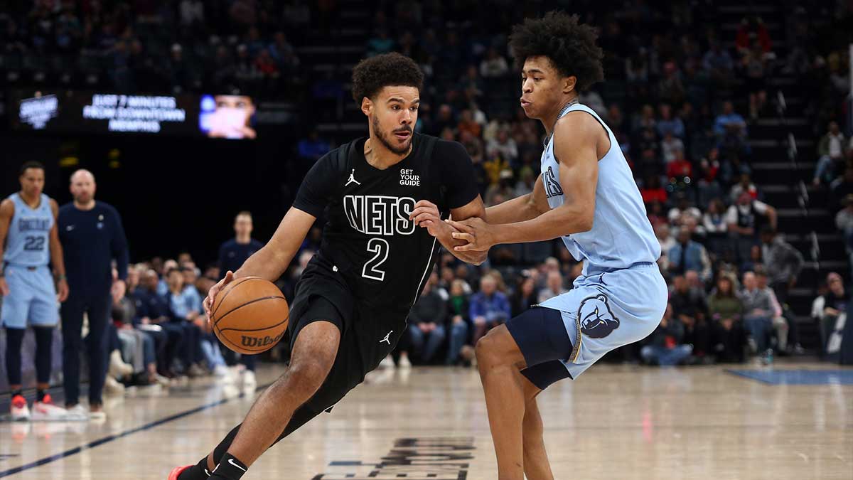 在 FedExForum 的第二节中，布鲁克林篮网队前锋卡梅伦·约翰逊 (Cameron Johnson) (2) 突破篮下，孟菲斯灰熊队前锋杰伦·威尔斯 (Jaylen Wells) (0) 防守。