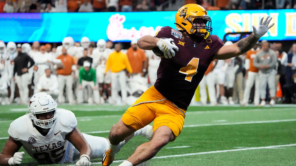 Arizona State running back Cam Skattebo (4) escapes a tackle by Texas defensive lineman Alfred Collins (95) during the fourth quarter in the Chick-fil-A Peach Bowl