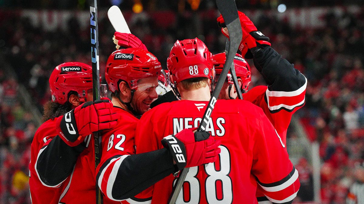 Carolina Hurricanes center Jesperi Kotkaniemi (82) is congratulated by center Martin Necas (88) defenseman Jalen Chatfield (5) and left wing Eric Robinson (50) after his goal against the Columbus Blue Jackets during the third period at Lenovo Center.