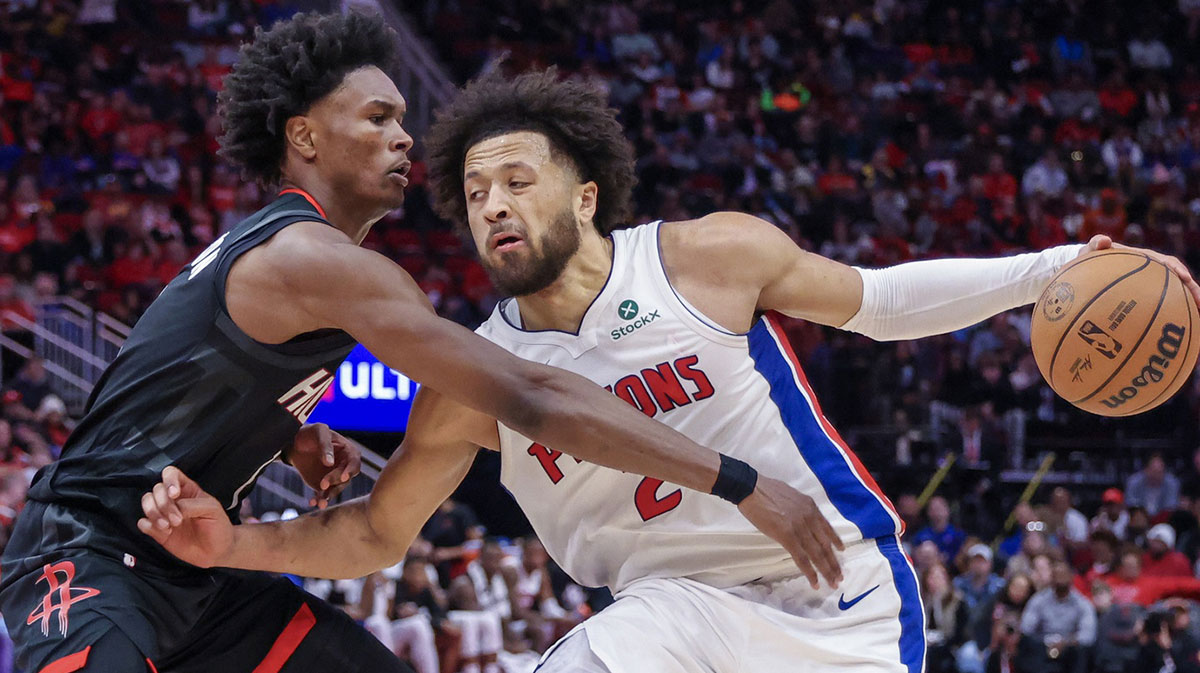 Detroit Pistons guard Cade Cunningham (2) dribbles past Houston Rockets forward Amen Thompson (1) in the second half at the Toyota Center.