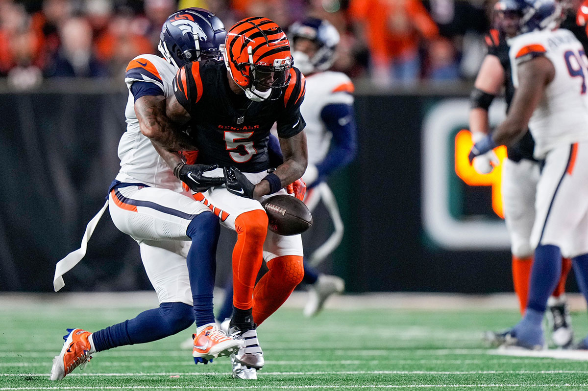 Cincinnati Bengals wide receiver Tee Higgins (5) fumbles a catch as he is wrapped up by Denver Broncos cornerback Pat Surtain II (2) in the fourth quarter of the NFL Week 17 game between the Cincinnati Bengals and the Denver Broncos at Paycor Stadium in downtown Cincinnati on Saturday, Dec. 28, 2024. The Bengals took a 30-24 win in overtime to remain in the post season chase.