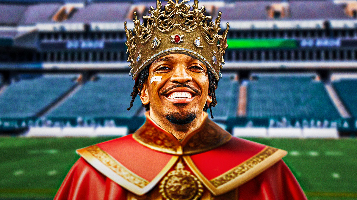 Commanders quarterback Jayden Daniels smiling/happy wearing crown and royal cape. Background is Lincoln Financial Field.