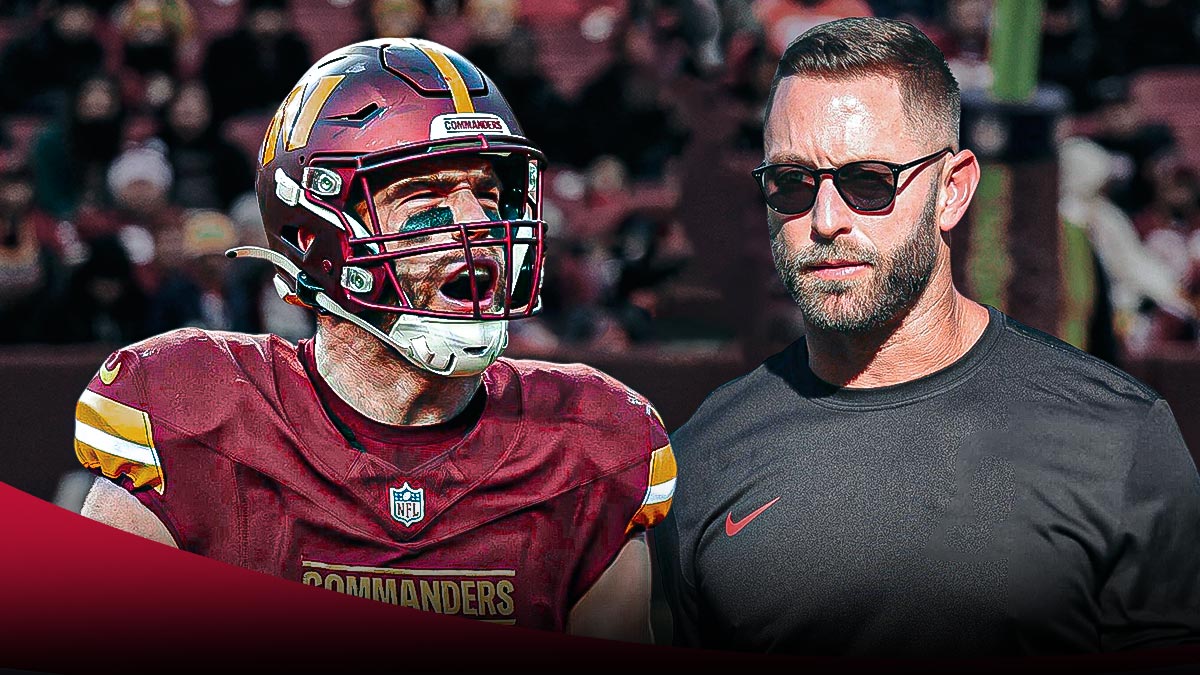 Zach Ertz next to Kliff Kingsbury in front of the Commanders stadium