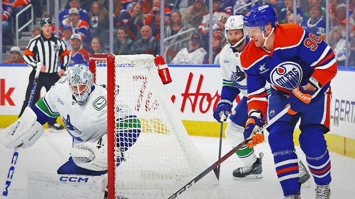 Edmonton Oilers forward Corey Perry (90) looks to make a pass in from behind Vancouver Canucks goaltender Thatcher Demko (35) during the first period at Rogers Place