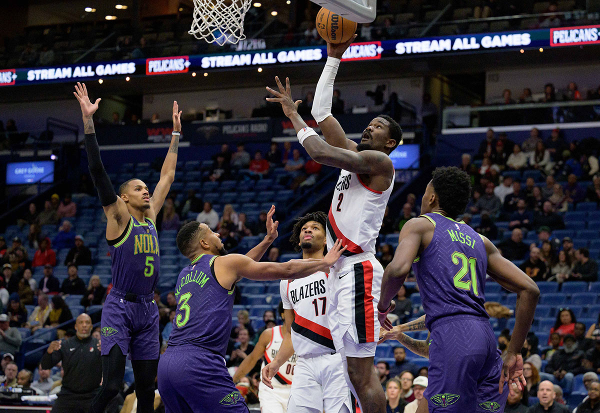 波特兰开拓者队中锋德安德鲁·艾顿 (Deandre Ayton) (2) 在冰沙国王中心 (Smoothie King Center) 下半场与新奥尔良鹈鹕队后卫 CJ 麦科勒姆 (CJ McCollum) (3) 投篮。